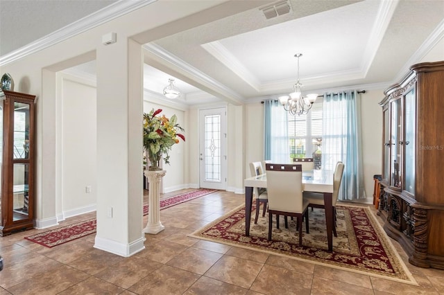 tiled dining space with decorative columns, a chandelier, a raised ceiling, and ornamental molding