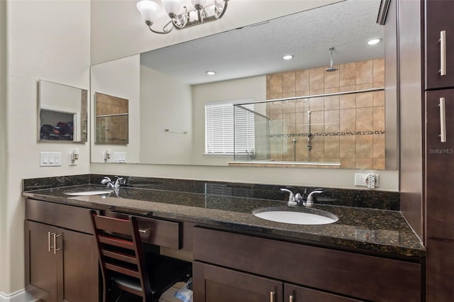 bathroom featuring a textured ceiling and double sink vanity