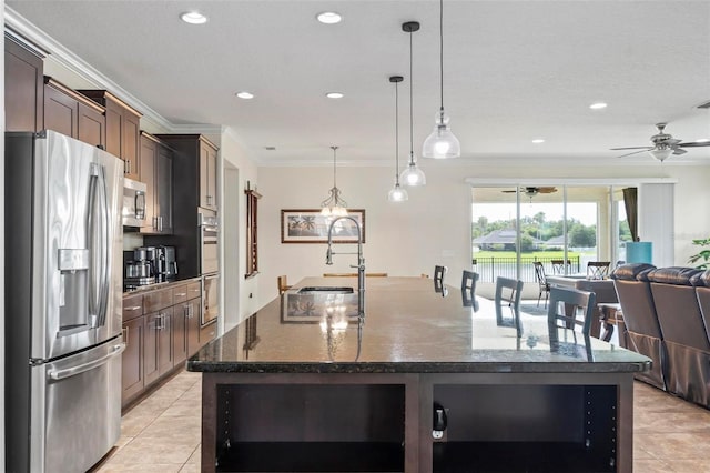 kitchen with dark brown cabinetry, light tile patterned floors, an island with sink, and stainless steel appliances