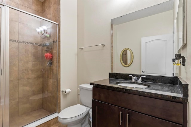 bathroom featuring a shower with shower door, vanity, and toilet