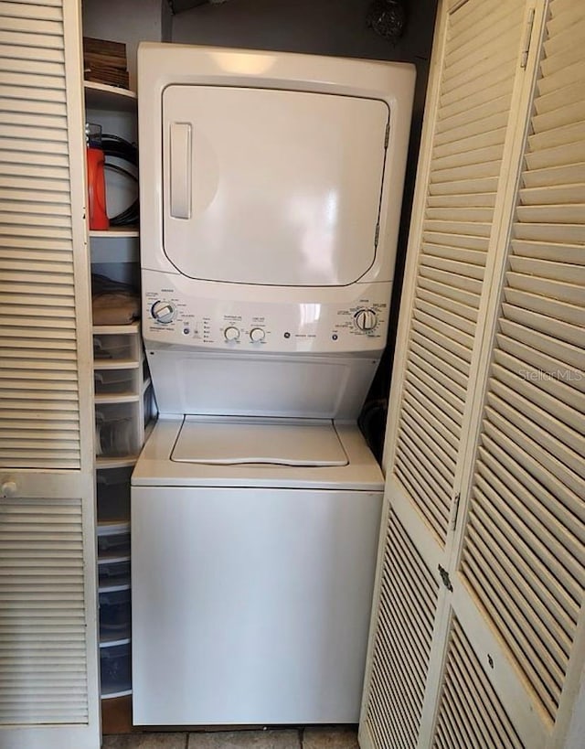 washroom featuring stacked washer and clothes dryer