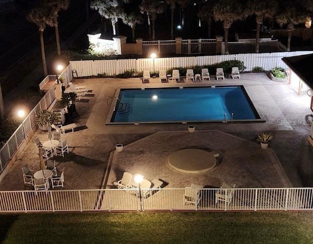 pool at twilight featuring a patio area