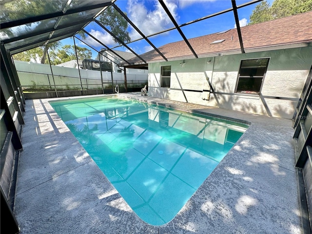 view of pool with a patio and glass enclosure