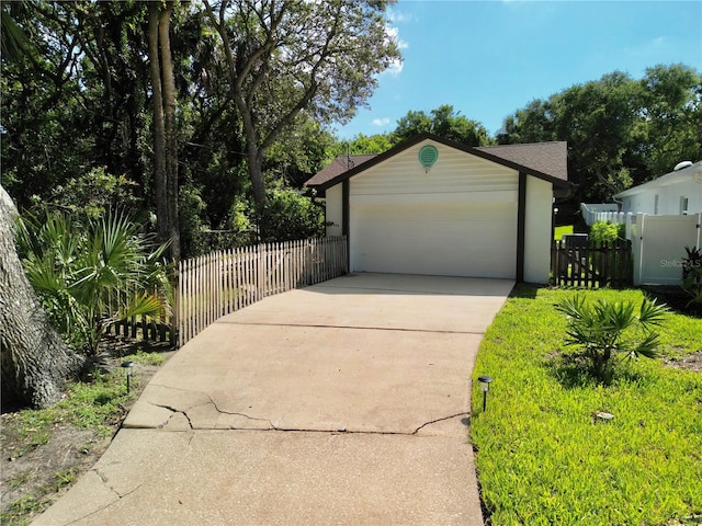 view of front of house with a garage, an outdoor structure, and a front yard