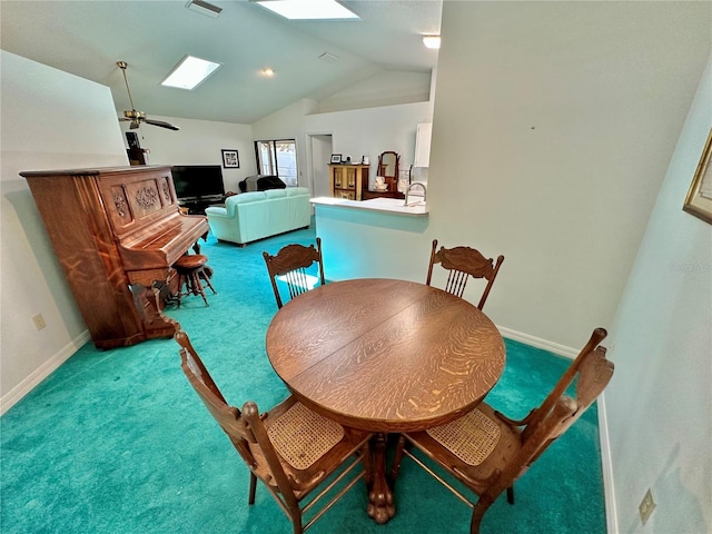 dining area with carpet, vaulted ceiling with skylight, and ceiling fan