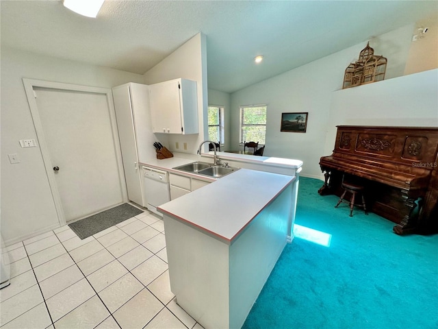 kitchen with white cabinetry, sink, dishwasher, vaulted ceiling, and light tile patterned floors