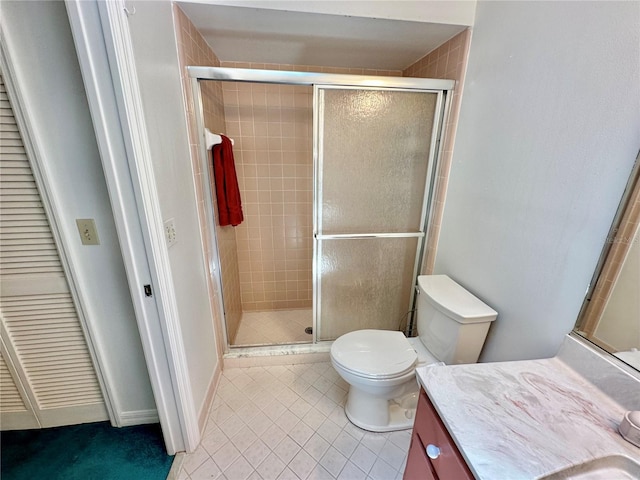 bathroom with vanity, walk in shower, tile patterned flooring, and toilet