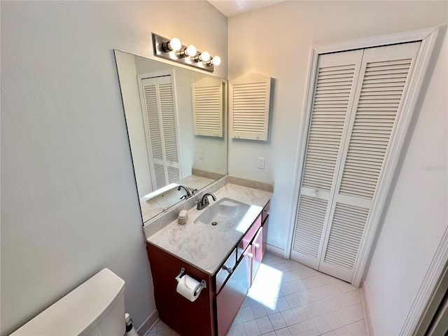 bathroom with vanity, toilet, and tile patterned flooring