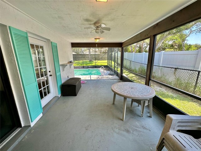 unfurnished sunroom with ceiling fan