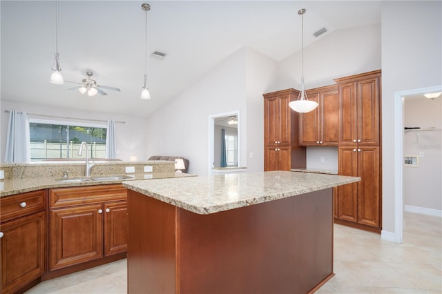 kitchen with hanging light fixtures, a kitchen island, sink, and ceiling fan