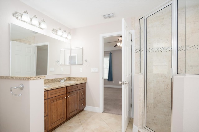 bathroom featuring ceiling fan, tile patterned floors, a shower with shower door, and vanity