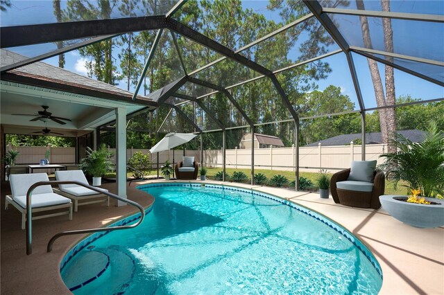 view of pool with ceiling fan, a lanai, and a patio