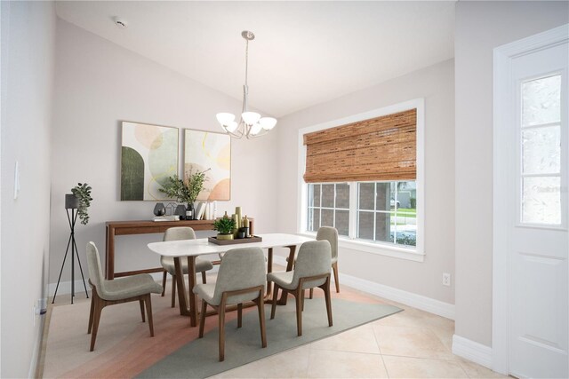 dining room featuring vaulted ceiling, light tile patterned flooring, and a notable chandelier