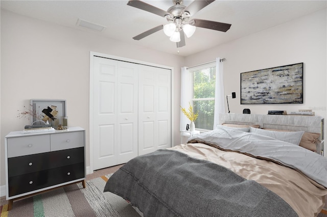 bedroom featuring ceiling fan, light colored carpet, and a closet