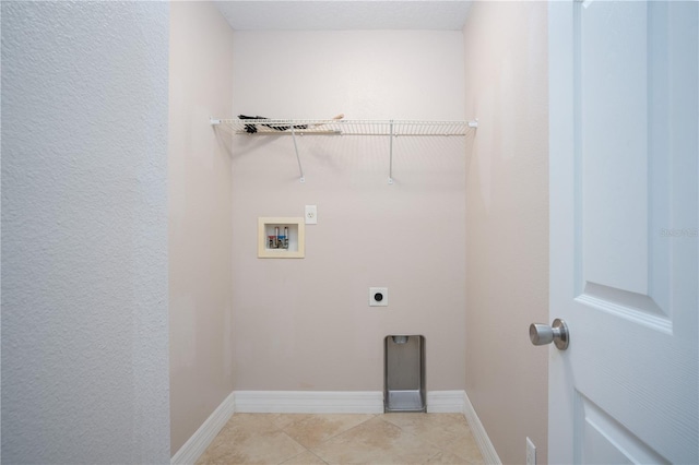 clothes washing area featuring electric dryer hookup, washer hookup, and light tile patterned floors