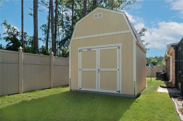 view of outdoor structure with cooling unit and a yard