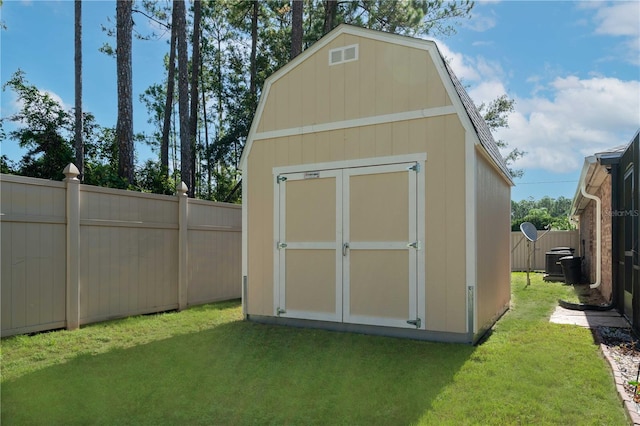 view of outbuilding featuring a lawn and central air condition unit