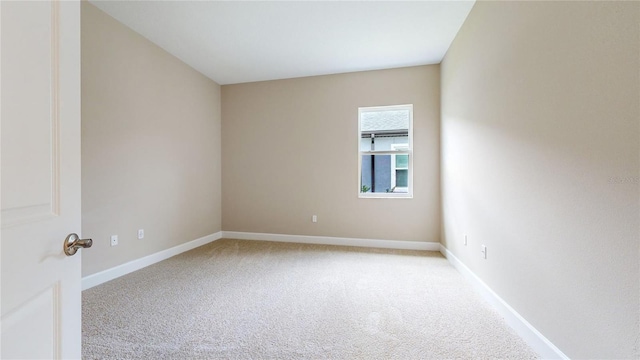 empty room with light carpet and baseboards