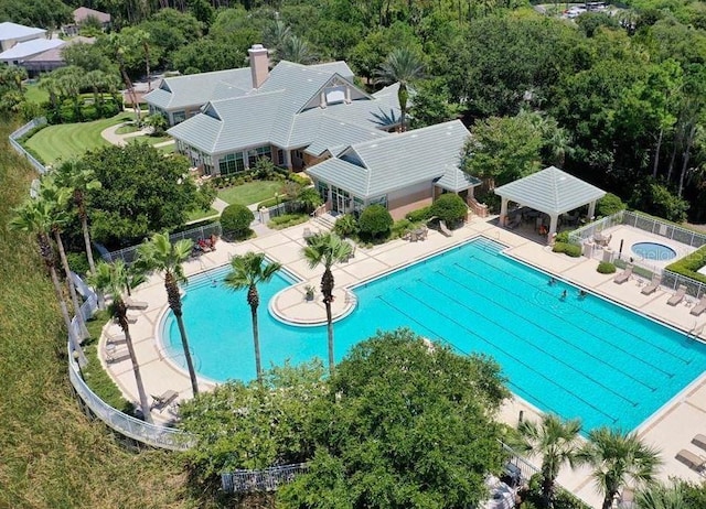 community pool with a gazebo, a patio, and fence