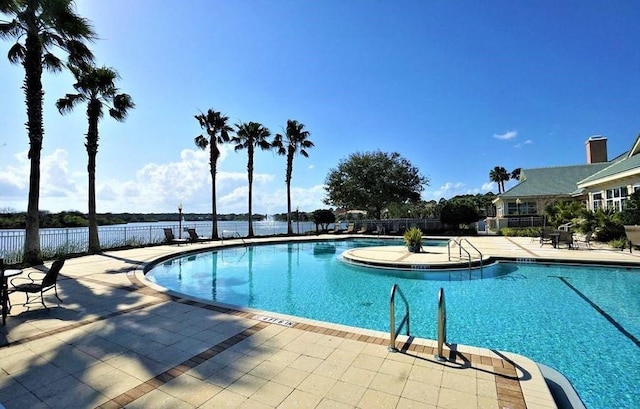 community pool with fence and a patio