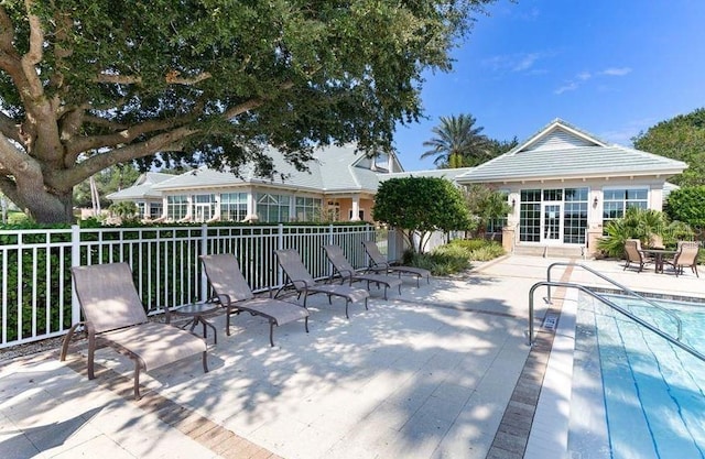 deck featuring an outbuilding, a patio area, fence, and a fenced in pool