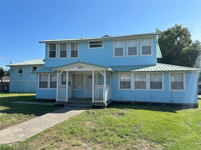 view of front of property featuring metal roof and a front lawn