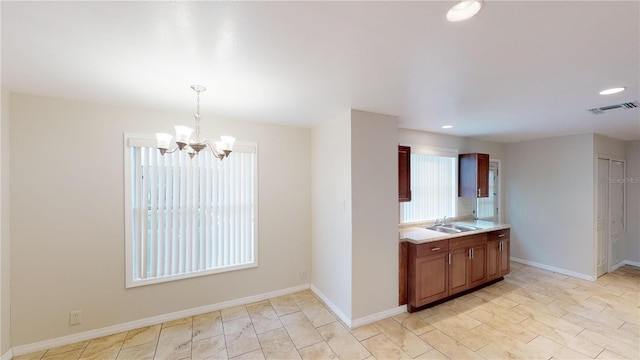 kitchen featuring a sink, visible vents, light countertops, a wealth of natural light, and decorative light fixtures