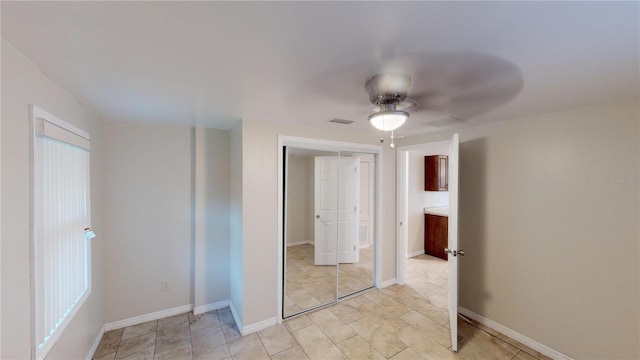 unfurnished bedroom featuring ceiling fan, a closet, visible vents, and baseboards