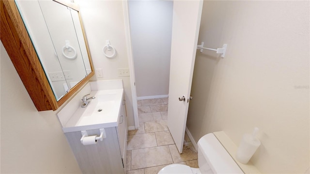 bathroom with baseboards, toilet, vanity, and tile patterned floors