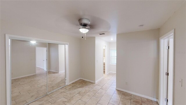 empty room featuring visible vents, ceiling fan, and baseboards