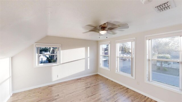 unfurnished sunroom featuring vaulted ceiling, visible vents, and a ceiling fan