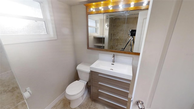 bathroom with toilet, vanity, and baseboards