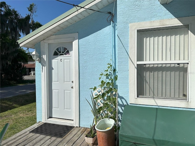 property entrance with stucco siding