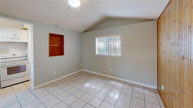 unfurnished room with wooden walls, baseboards, vaulted ceiling, and light tile patterned flooring