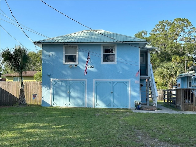 view of side of property with metal roof, a yard, an outdoor structure, and fence