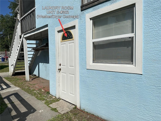 property entrance with stucco siding