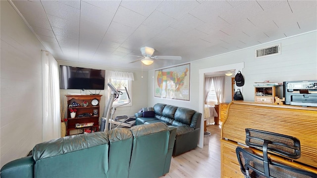 living room with light wood-style floors, visible vents, and a ceiling fan