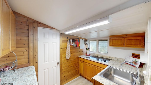 kitchen featuring lofted ceiling, light countertops, black electric stovetop, and a sink