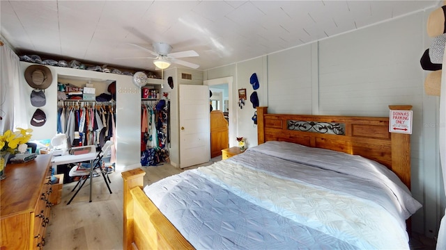 bedroom with light wood-style flooring, visible vents, and a ceiling fan