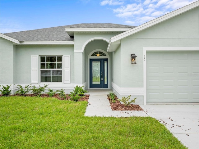 view of exterior entry featuring a yard and a garage