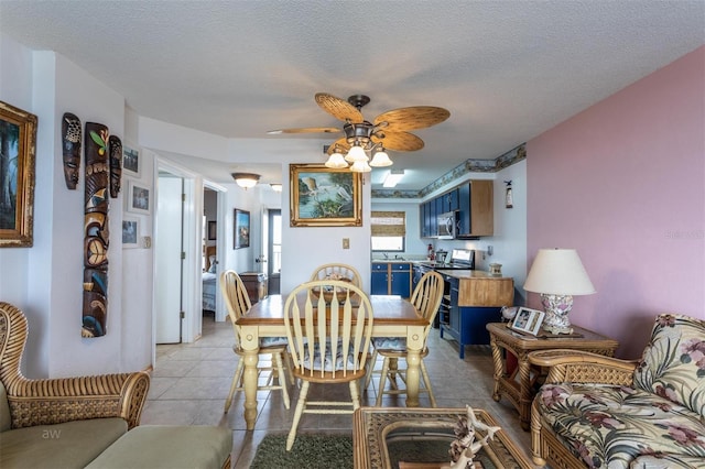 dining space with a textured ceiling, ceiling fan, and light tile patterned floors