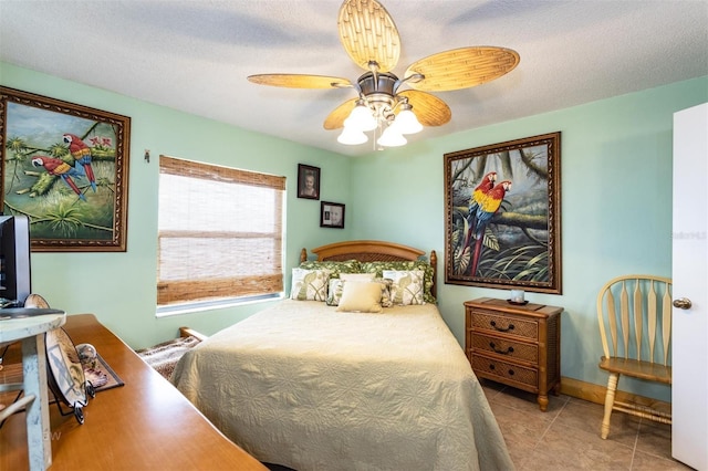 bedroom featuring a textured ceiling, ceiling fan, and light tile patterned floors