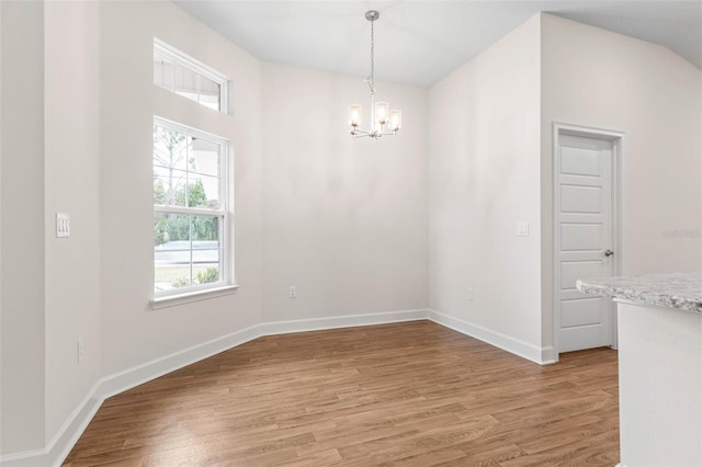 unfurnished room featuring wood-type flooring and a notable chandelier