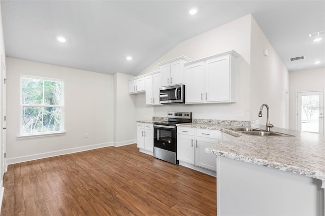 kitchen featuring sink, white cabinetry, appliances with stainless steel finishes, and lofted ceiling