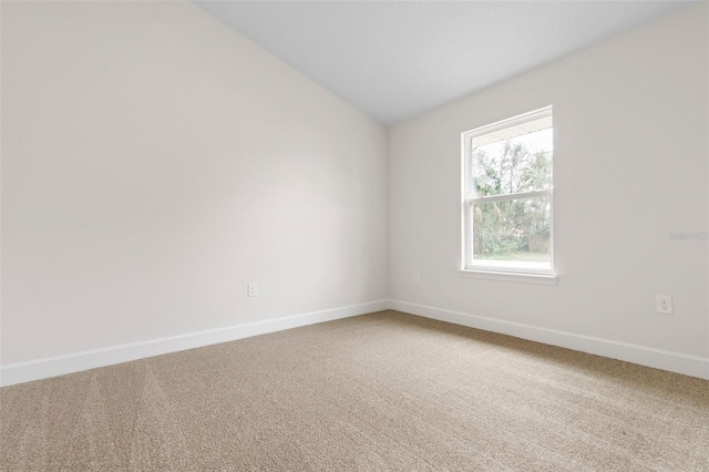 unfurnished room featuring vaulted ceiling and carpet