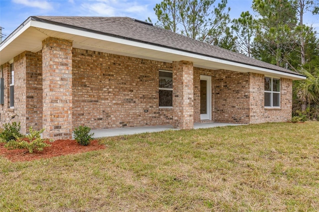 rear view of house with a lawn and a patio