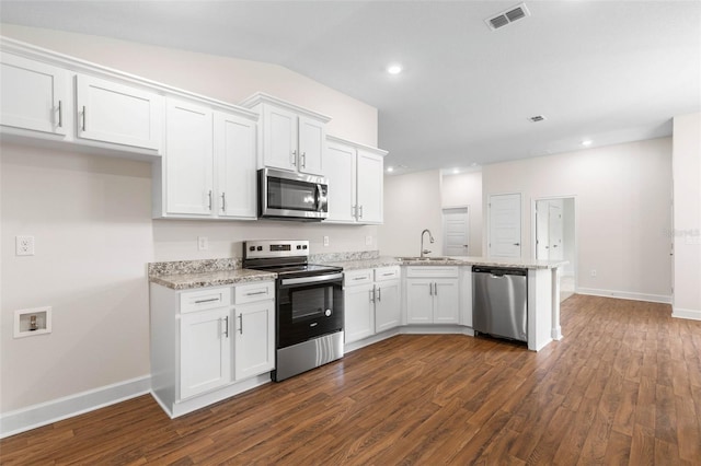 kitchen with kitchen peninsula, white cabinets, dark hardwood / wood-style flooring, and appliances with stainless steel finishes