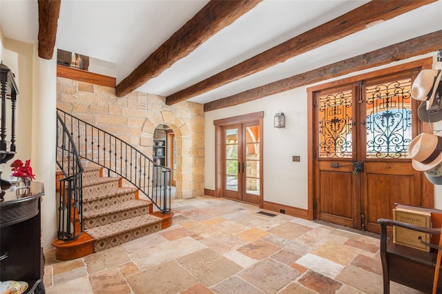 entryway with beam ceiling and french doors