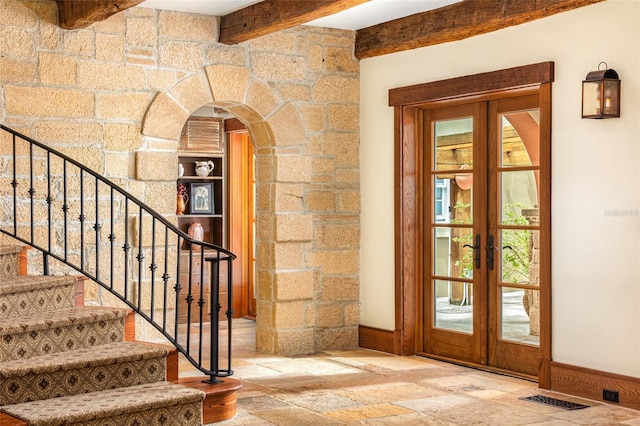 doorway to outside with beamed ceiling and french doors