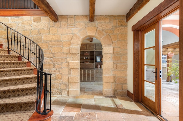 wine area featuring beamed ceiling and french doors